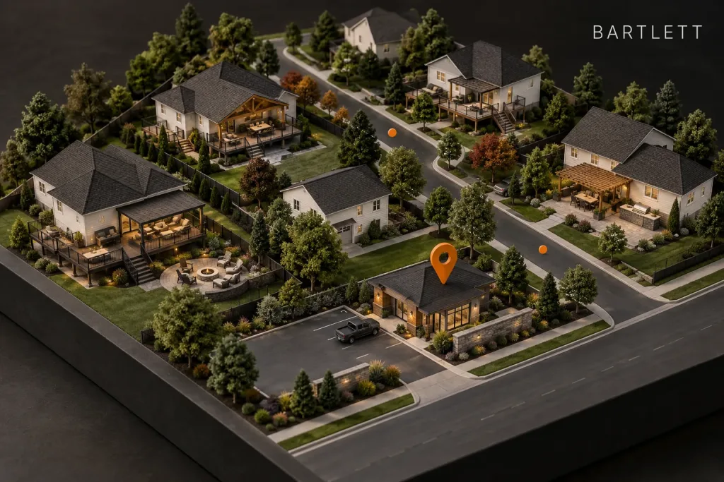 Scale model of a suburban neighborhood with decks and patios, marked by an orange map pin over a contractor's shop, labeled Bartlett, IL