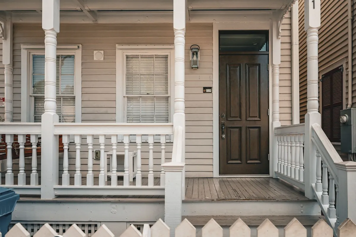 A charming wooden house porch with a decorative entrance and picket fence, symbolizing local business appeal.