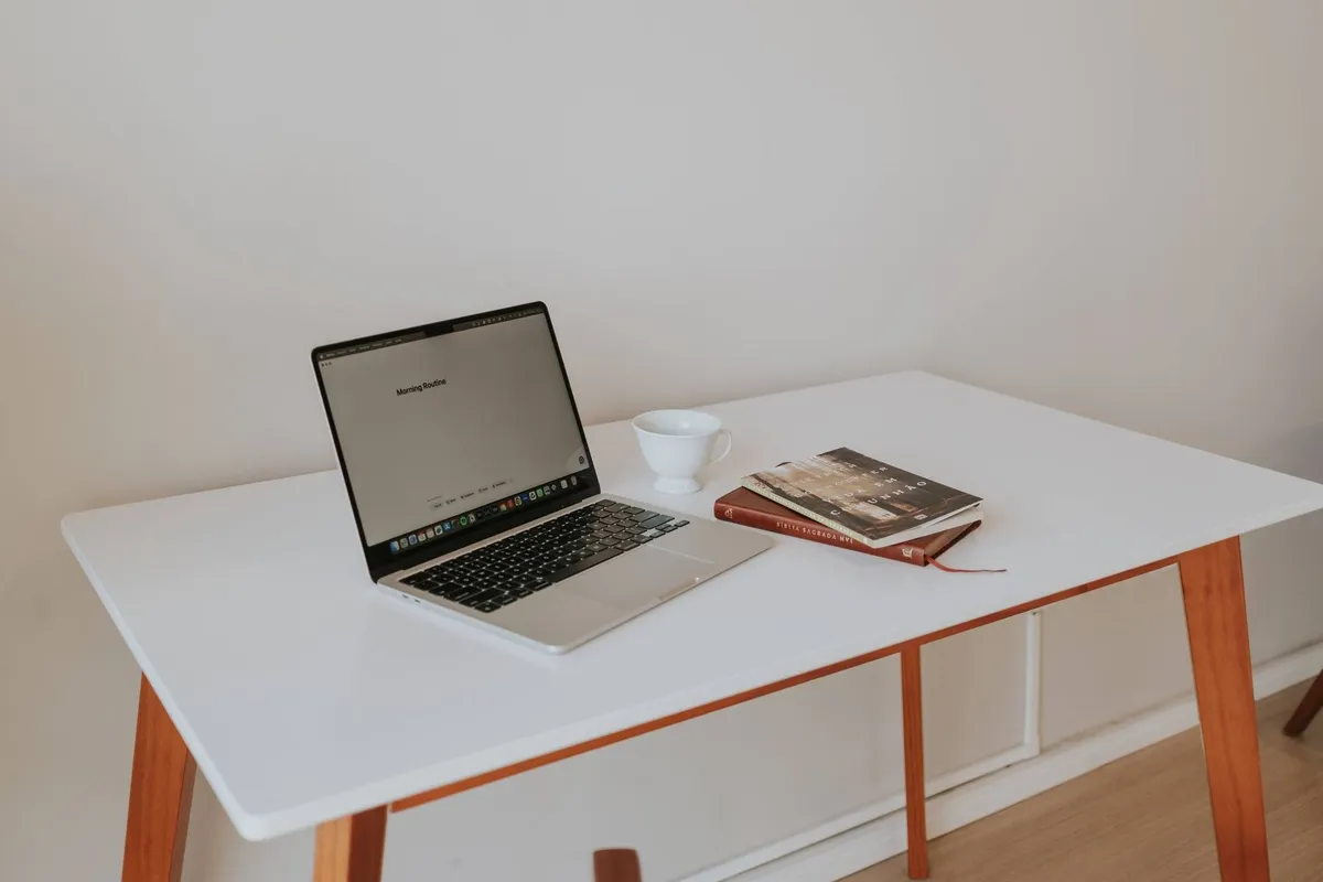 A minimalistic workspace with a laptop, coffee cup, and books, reflecting a focus on digital marketing.